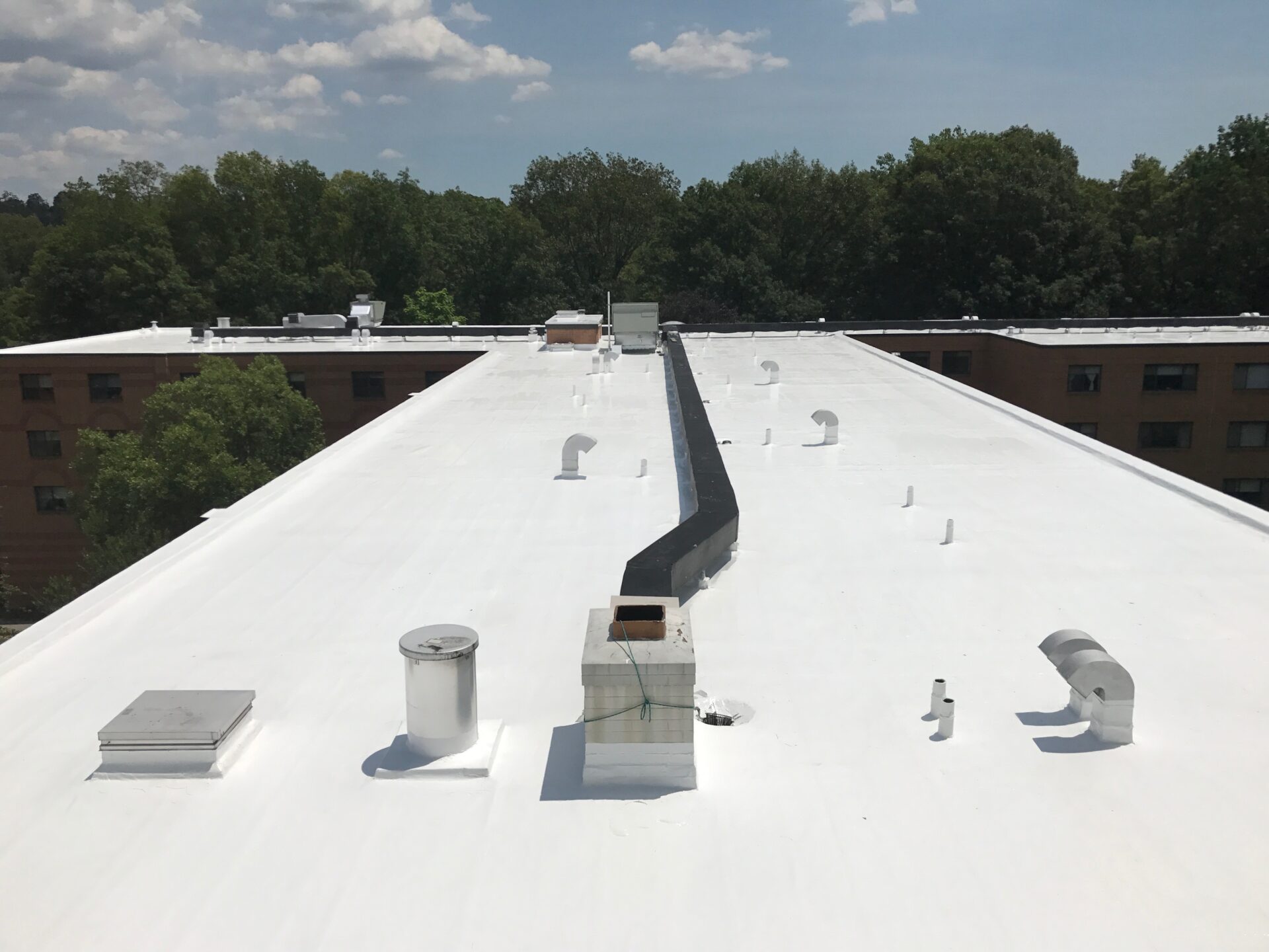 A white roof with a black vent on it